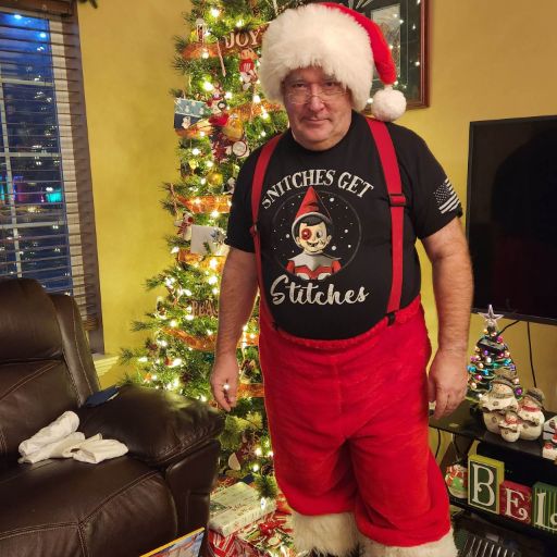 Santa getting ready for Christmas while representing his Snitches Get Stiches t-shirt.