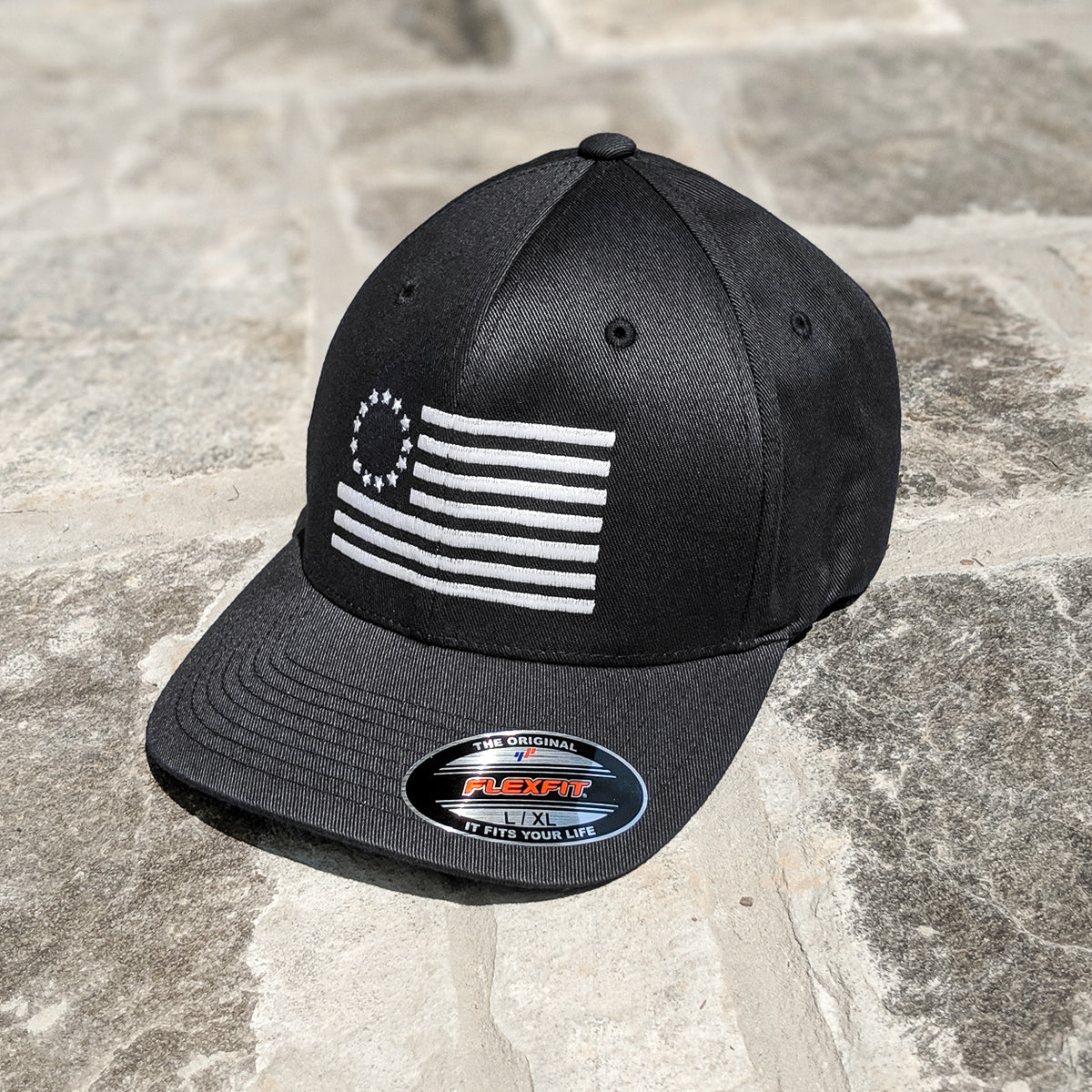 Betsy Ross Flag Flexfit features the Betsy Ross Flag embroidered on a black flexfit hat.