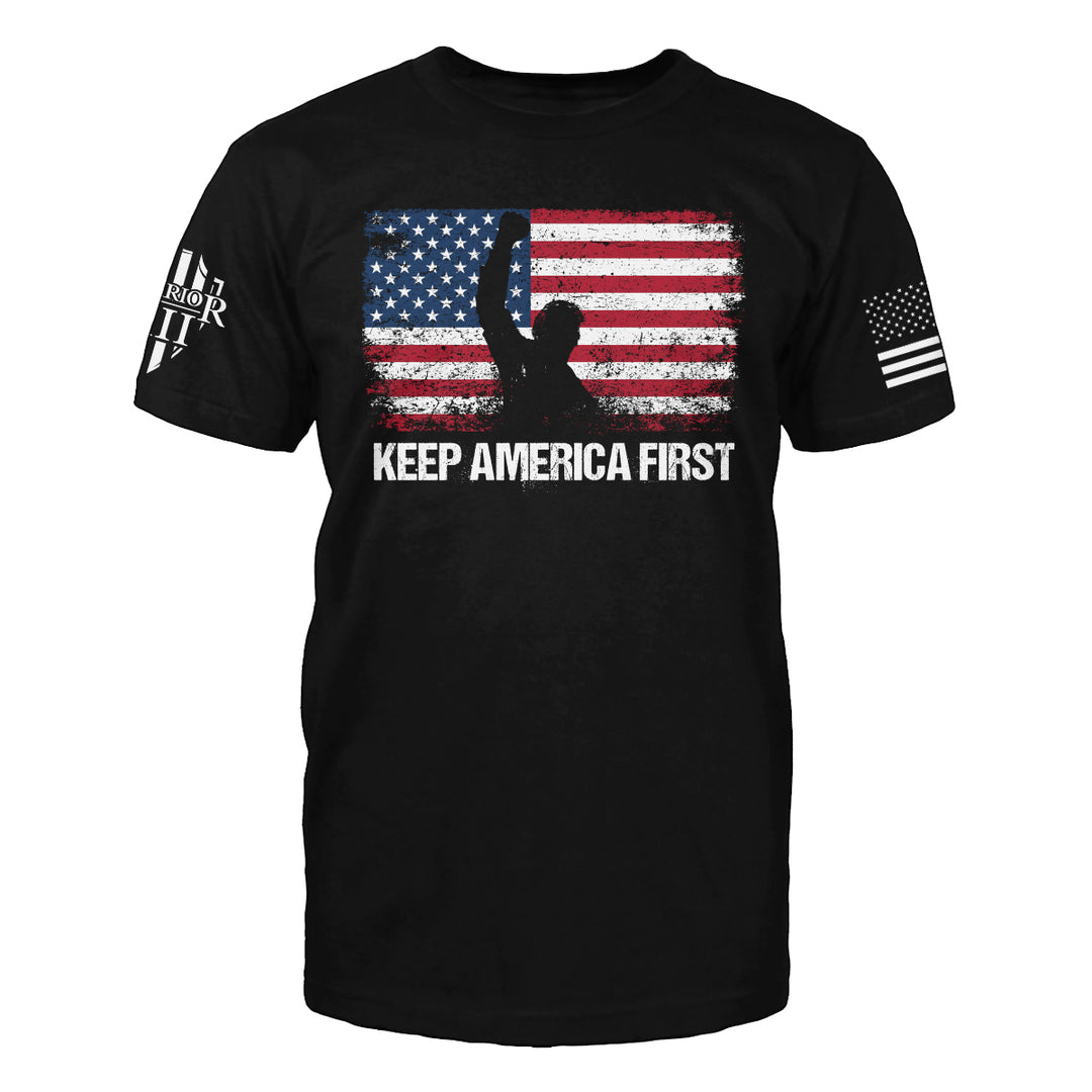 Front black t-shirt with the main design, "US Flag standing in front with his hand raised after he was shot at, with Keep America First written below" printed.