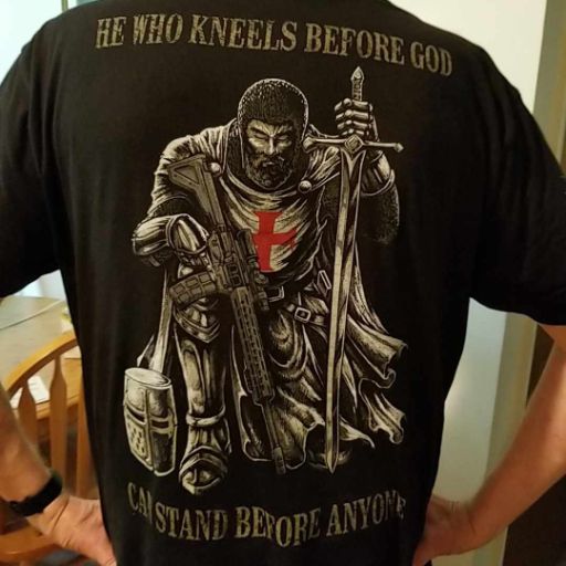 A customer enjoying their new He Who Kneels Before God T-shirt.