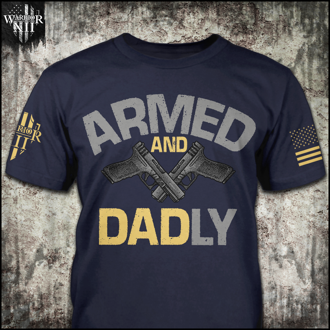 Navy t-shirt with the words "Armed and Dadly" Under the word armed, is a set of black handguns and then 'Dadly' written below the guns with the word DAD being in a yellow with a grey L and Y