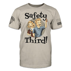 A light-tan t-shirt with an image on the front of a boy and girl child holding a lit firecracker and switchblade with the words "Safety Third!"