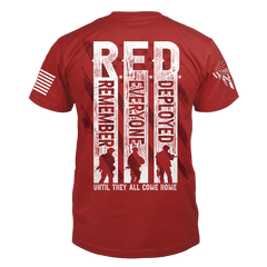 The back of a red t-shirt which has an image with silhouettes of solders with the words "Remember Everyone Deployed, until they call come home."