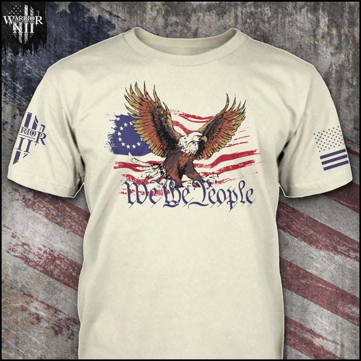 "We The People" is printed on a natural color t-shirt with the main design printed on the front and the back of this t-shirt has no printing. This shirt features our brand logo on the right sleeve and the American Flag on the left sleeve.