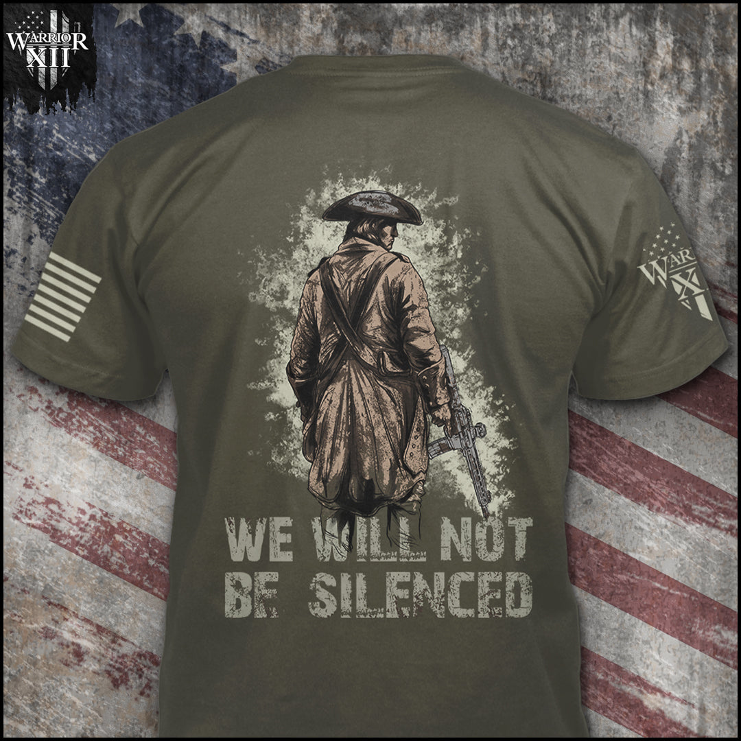 We Will Not Be Silenced is printed on a military green t-shirt with the main design printed on the back and a small print on the front left chest.  This shirt features our brand logo on the right sleeve and the American Flag on the left sleeve. 