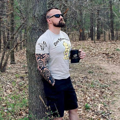 One of our awesome customers enjoying a hot cup of coffee outdoors while wearing our Zero Bothers Given t-shirt.
