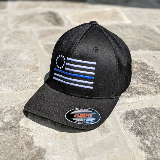 A Thin Blue Line Betsy Ross Flexfit that features the Thin Blue Line Betsy Ross Flag embroidered on a black flexfit hat.