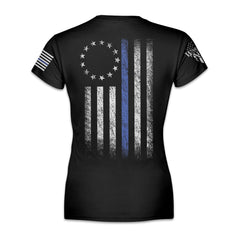 A black women's relaxed fit'shirt that features a thin blue line Betsy Ross flag on a back print to show that we remain undeterred in our support for American law enforcement. printed on the back of the shirt.