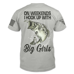 The back of a light grey shirt featuring the image of a jumping largemouth bass hooked on a lure with the words "On weekends I hook up with big girls."