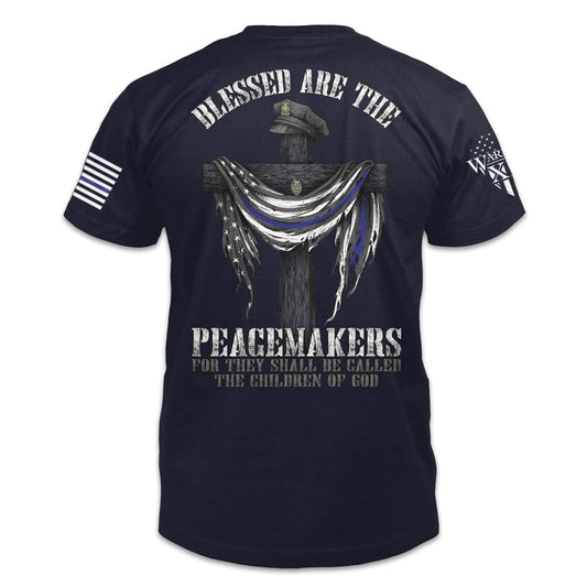 Blessed Are The Peacemakers navy blue t-shirt with the cross, a police hat, and the back the blue flag printed on the back of the shirt.