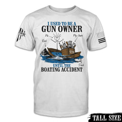 A white tall size shirt with the words "I Used to be A Gun Owner Until The Boating Accident" and design of a stick man with guns on a sinking ship printed on the front.