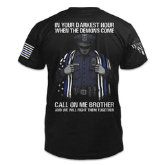 Black t-shirt with the words "In your darkest hour when the demons come, call on me, brother, and we will fight them together" with a police officer holding a flag printed on the back of the shirt.