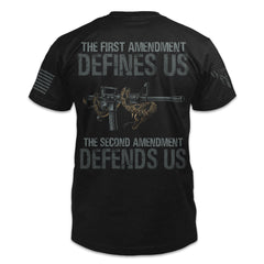 The back of a black t-shirt featuring an image of a rattlesnake coiled around a rifle with the words "The First Amendment defines us, the Second Amendment defends us."