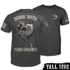 An asphalt grey t-shirt featuring a an upside-down skull with a foamy beverage coming out of the skull on the front and back. The back has the words "Drink with your enemies."