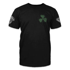 A black t-shirt with a green clover printed on the front.