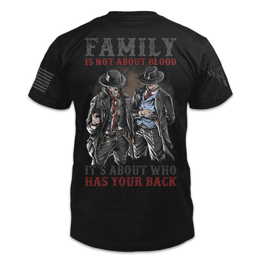 A black t-shirt with the words "Family is not about blood, it's about who has your back" with a two western cowboys printed on the back of the shirt.