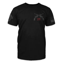 A black t-shirt with two pistols crossed over with the roman numerals XII printed on the front of the shirt.
