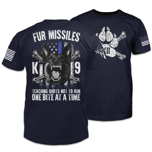 Front & back navy blue t-shirt with the words "Fur Missiles, Teaching Idiots Not To Run, One Bite At A Time!" featuring a german shepherd showing teeth in front of a thin blue line USA flag printed on the shirt.