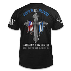 A black t-shirt with the words 'Greek by blood, American by birth, patriot by choice" and a cross with the Greek and USA flag hanging over it printed on the back of the shirt.
