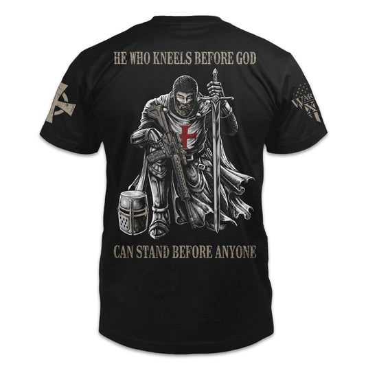 A black t-shirt with the words "He who kneels before God can stand before anyone" with a knights templar kneeling holding a sword printed on the back of the shirt.