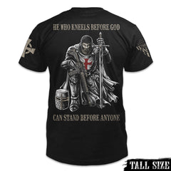 A black tall size shirt with the words "He who kneels before God can stand before anyone" with a knights templar kneeling holding a sword printed on the back of the shirt.
