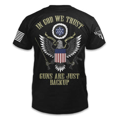A black t-shirt with the words "In God we trust, guns are just backup" with an american eagle and the USA flag printed on the back of the shirt.