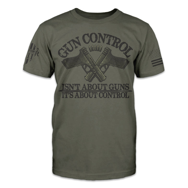 An olive green t-shirt with the words "Gun control isn't about guns, it's about control" and two guns crossed over printed on the front of the shirt.