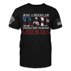 A black t-shirt with the words "Just a regular dad trying not to raise liberals" printed on the front.