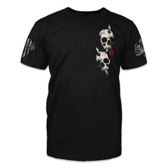 A black t-shirt with two skulls with arrows through them printed om the front.