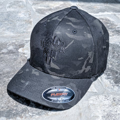 A Flexfit that features the Warrior 12 shield embroidered on a Multicam black flexfit hat.