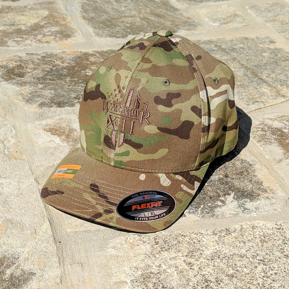 A Flexfit hat that features the Warrior 12 shield embroidered on a Multicam green flexfit hat.