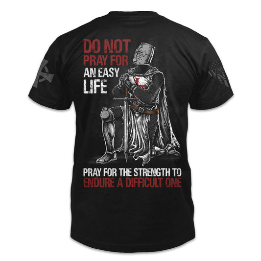 A black t-shirt with the words "Do not pray for an easy life, pray for the strength to endure a difficult one" with a kneeling knight templar printed on the back of the  shirt.