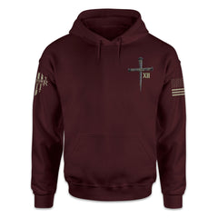 A burgundy hoodie with a cross printed on the front.