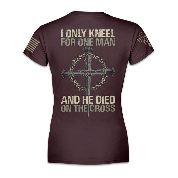 A burgundy women's relaxed fit'shirt with the words "I only kneel for one man, and he died on the cross" with a cross printed on the back of the shirt.