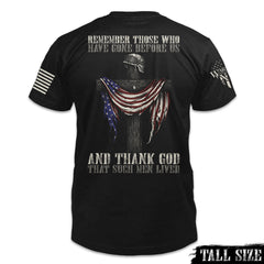 A black tall size shirt with the words "Remember those who have gone before us, and thank God that such men lived" with a cross holding a helmet and American flag printed on the back of the shirt.