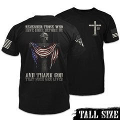 Front & back black tall size shirt with the words "Remember those who have gone before us, and thank God that such men lived" with a cross holding a helmet and American flag printed on the shirt.