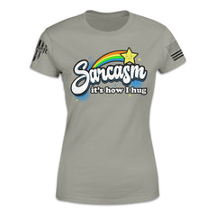 A grey women's relaxed fit'shirt with the words "Sarcasm; it's how I hug" with a rainbow and shooting star printed on the front of the shirt.