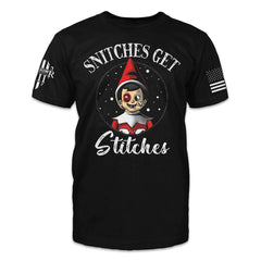 A black t-shirt with the words "Snitches get stitches" with a beaten up elf on the shelf printed on the front of the shirt.