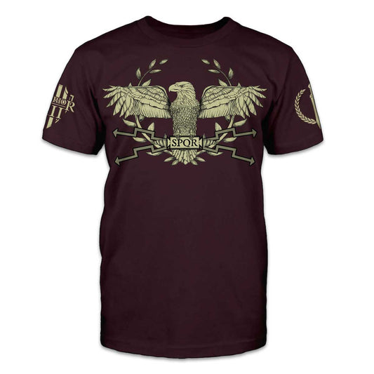 A burgundy t-shirt that features the Roman Aquila (Roman eagle) and represents the icon for one of the strongest and most lethal forces to ever walk the earth, the legions of the Roman Empire printed on the front of the shirt.