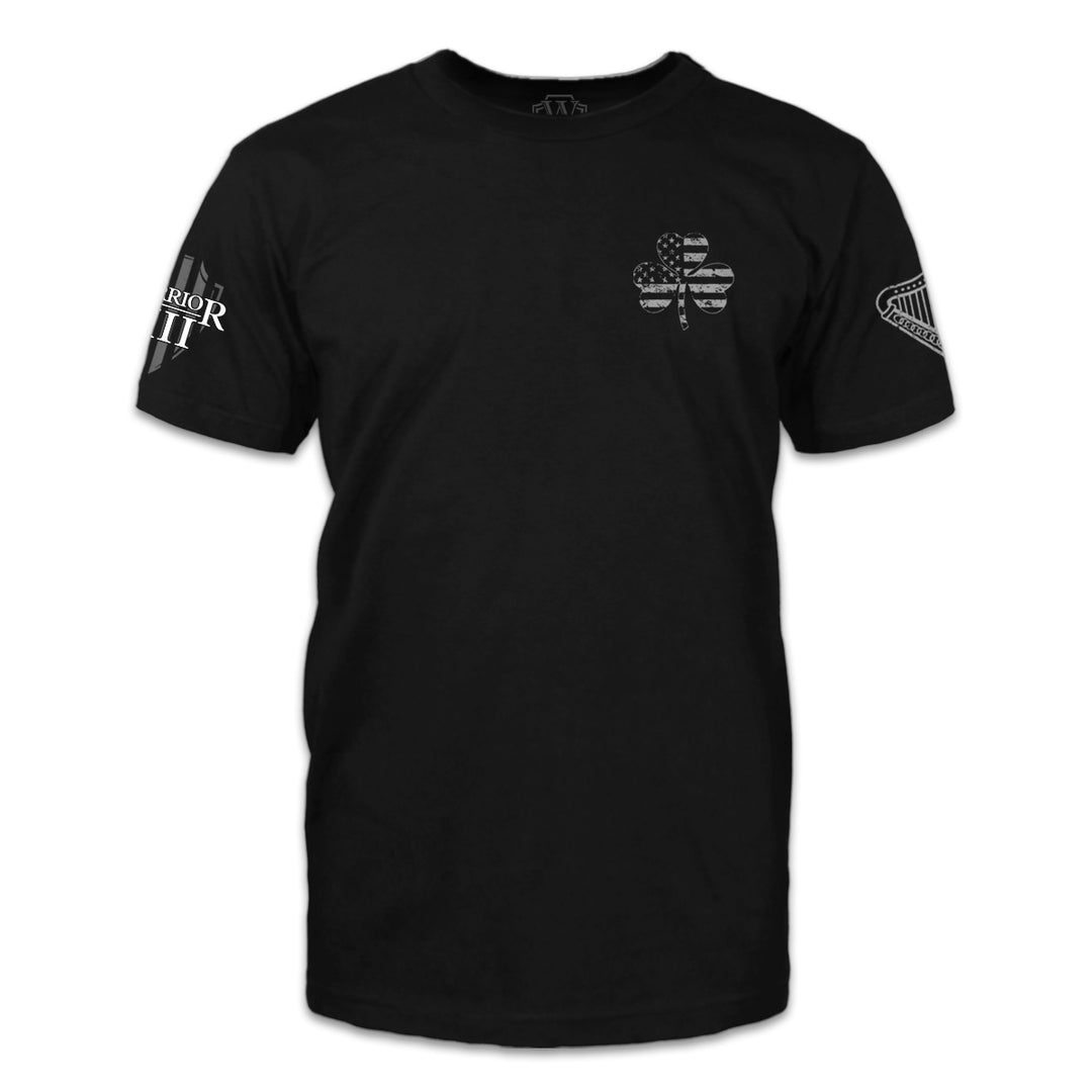 A black t-shirt with a clover printed on the front of the shirt.