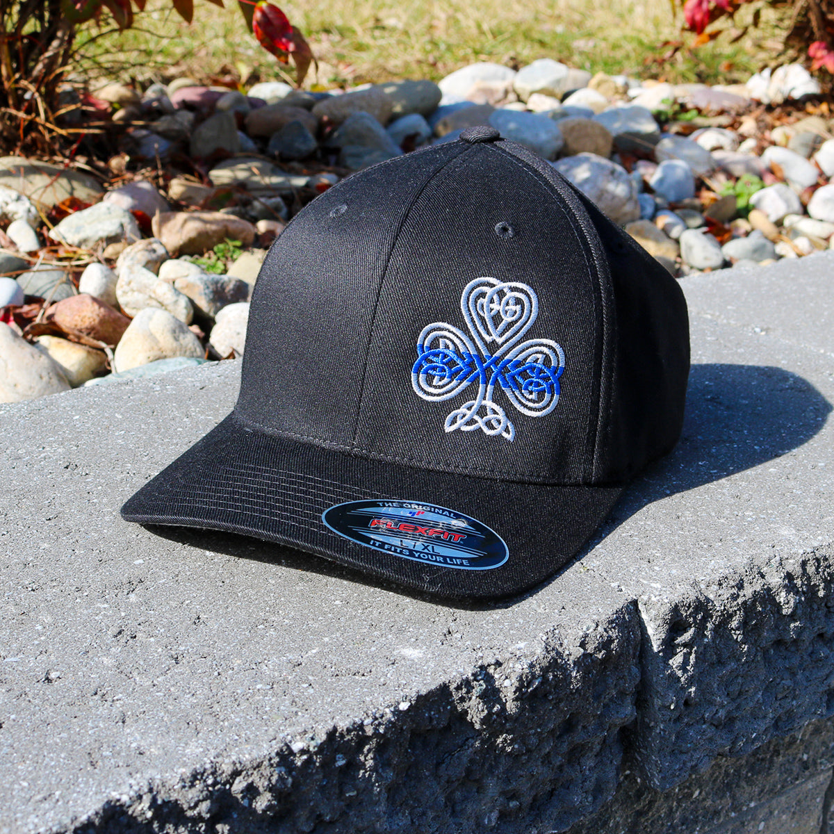 A Thin Blue Line Shamrock Flexfit that is embroidered on a black flexfit hat.