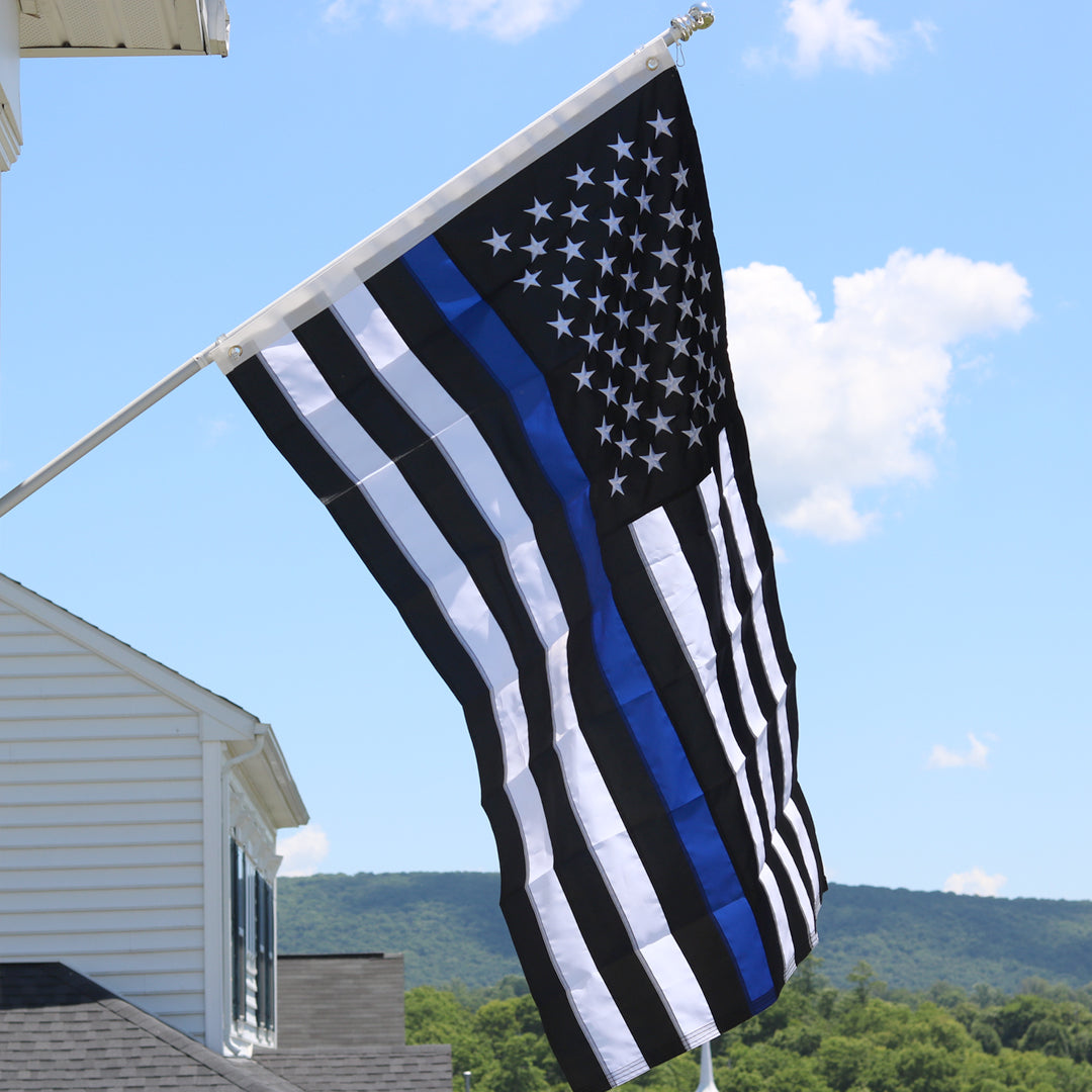 The Embroidered Thin Blue Line Flag hanging from a flag pole.