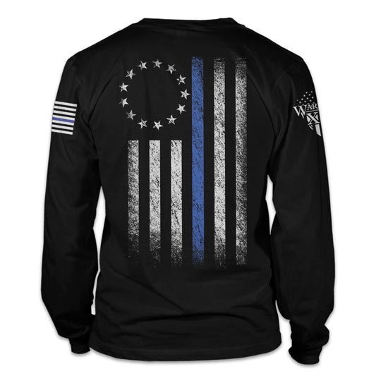 A black long sleeve shirt that features a thin blue line Betsy Ross flag on a back print to show that we remain undeterred in our support for American law enforcement. printed on the back of the shirt.