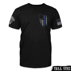 A black tall size shirt with the thin blue line betsy ross flag printed on the front left chest of the shirt.