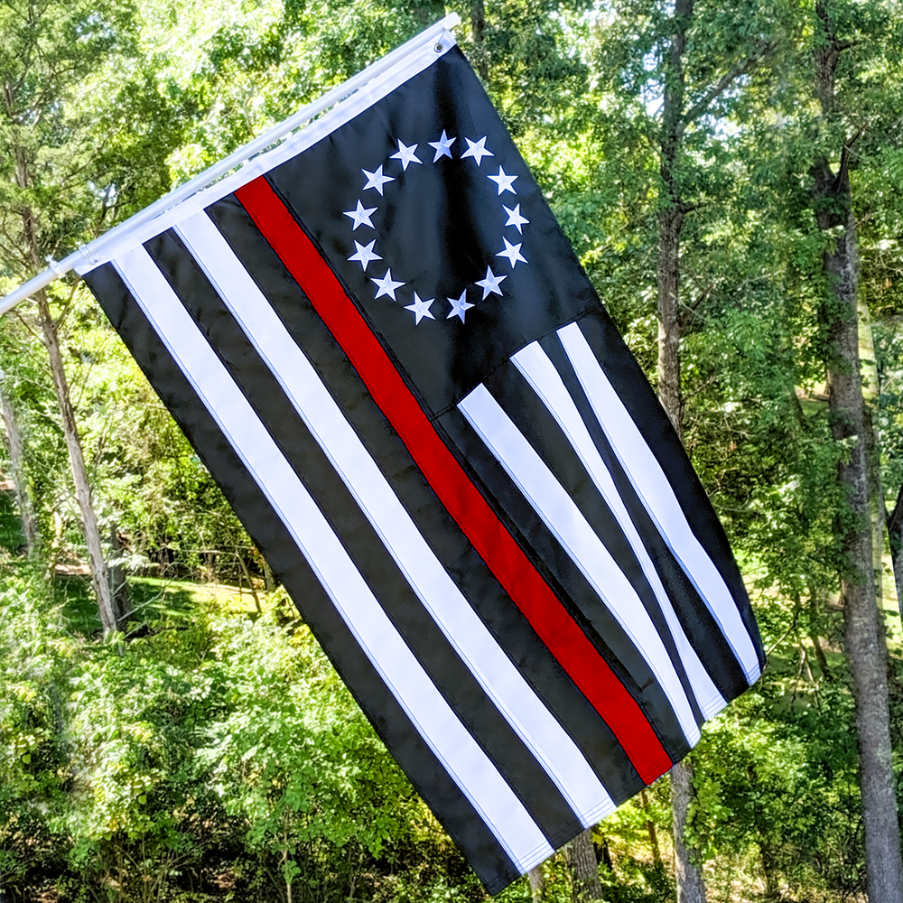 Embroidered Thin Red Line Betsy Ross Flag hanging from a flag pole.